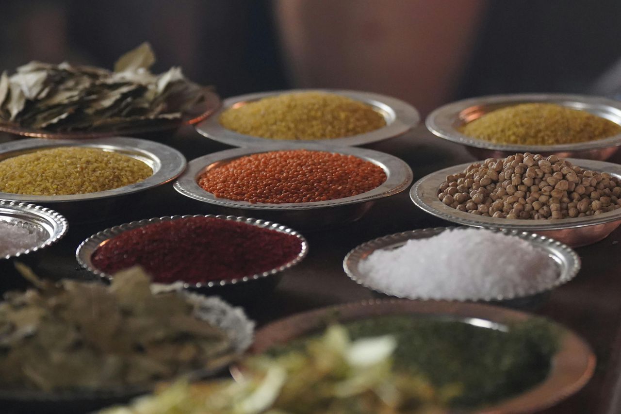Close-up of assorted spices and grains in metal bowls showcasing culinary variety.